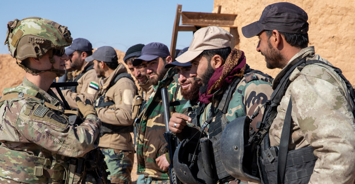 U.S. Army 2nd Lt. Zach Panici, a platoon leader assigned to 10th Mountain Division, Task Force Armadillo, speaks with Syrian Free Army (SFA) soldiers at a combat outpost in the Deconfliction Zone, Syria, Feb. 7, 2025. Coalition Forces assessed the outpost’s conditions and trained SFA soldiers on personnel and vehicle searches, as well as checkpoint operations. The Coalition remains committed to advising, assisting, and enabling partner forces to ensure ISIS remains defeated and to maintain regional security and stability. (U.S. Army photo by Staff Sgt. Fred Brown)